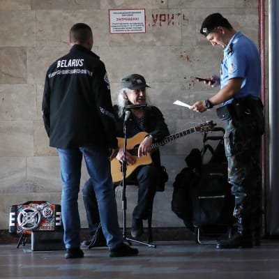 Belarusisk polis granskar en musikers dokument i Belarus huvudstad Minsk.