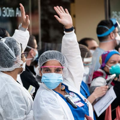 Sjukvårdspersonal utanför Mont Sinai-sjukhuset i Queens, New York, reagerar på hyllningar från stadens invånare.