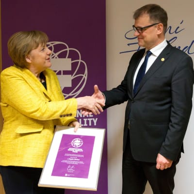 Juha Sipilä överräcker priset åt Angela Merkel.