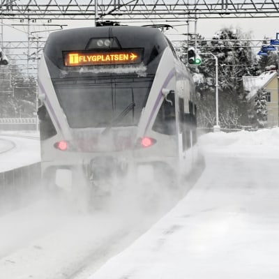 Tåget till flygplatsen i Helsingfors fotograferat i snöyra på Mosabackas tågstation. 