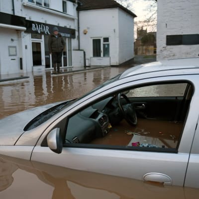 Bil som svämmats över av brunt vatten. 