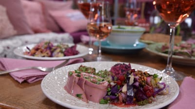 Portion med buffemat och rosevin på ett bord.