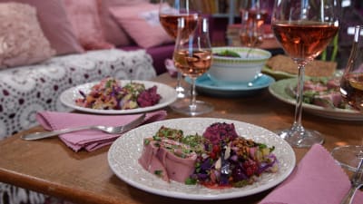 Portioner med buffémat och rosevin på ett bord.