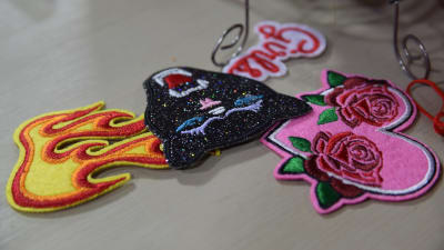 Broderade tygmärken som man kan fästa som dekoration på ett klädesplagg. Tygmärkena föreställer en eldslåga, en panter och ett rosa hjärta med rosor på.