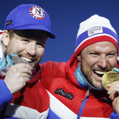 Kjetil Jansrud och Aksel Lund Svindal biter i sina medaljer.