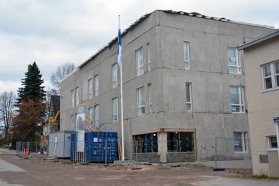 Ett hus som ännu är halvfärdigt med en flaggstång utanför med flaggan i topp.