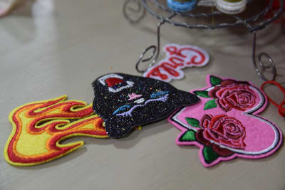 Broderade tygmärken som man kan fästa som dekoration på ett klädesplagg. Tygmärkena föreställer en eldslåga, en panter och ett rosa hjärta med rosor på.