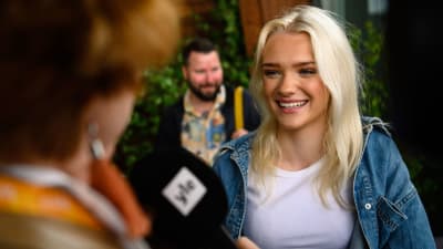 ung blong tjej med långt hår ler mot en journalist med ylemikrofonMarcus och Martinus