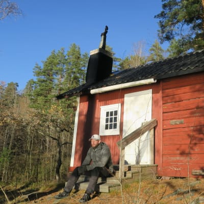 Mikael Hed istuu I.K.Inhan vuonna 1902 rakennuttaman mökin portailla Karjalohjan Heponiemessä.