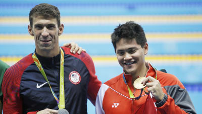 Två simmare med varsin medalj av olika valör.