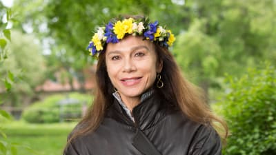 Skådespelare Lena Olin med blomsterkrans i håret.