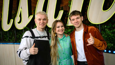 Tvillingartisterna, Marcus och Martinus poserar men tummen upp och har jazzsångerskan Iris Bergcrantz mellan sig. Alla ler glatt framför texten Allsång på Skansen.