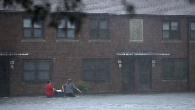 Folk försöker rädda sina ägodelar från sina hem och vadar genom vattenmassorna på en gata i New Bern i North Carolina i samband med orkanen Florence.