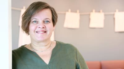 Pamela Granskog står och ler iklädd en mossgrön tröja.