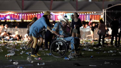 en person i rullstol evakueras från en festival i Las Vegas där skottlossning ägt rum