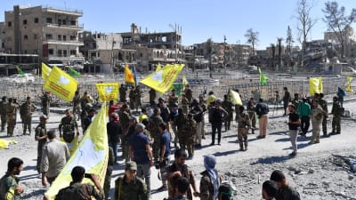 Medlemmar av syriska demokratiska styrkorna SDF uppbackade av amerikanska styrkor  samlas vid ett torg i Raqqa 17.10.2017.