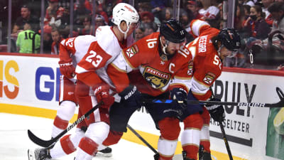 Aleksander Barkov och MacKenzie Weegar försöker hålla Detroitspelaren Lucas Raymond på avstånd.