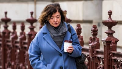 Brittiska regeringstjänstemannen Sue Gray vandrar utomhus i London med en kaffemugg i handen.