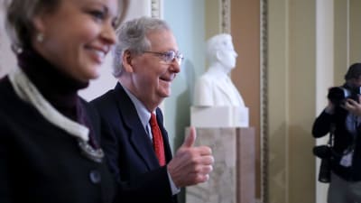 Senatens majoritetsledare Mitch McConnell visade tummen upp då han och hans medarbetare Stephanie Muchow var på väg in i senaten, inför omröstningen. 
