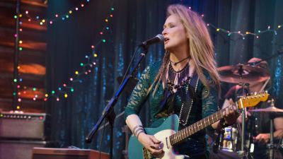 Meryl Streep rockar loss med en gitarr på scenen
