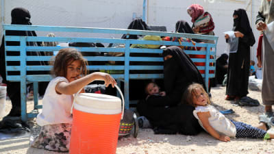 Syriska kvinnor och barn väntar på transport bort från det överfyllda lägret al-Hol i Syrien. Juni 2019.
