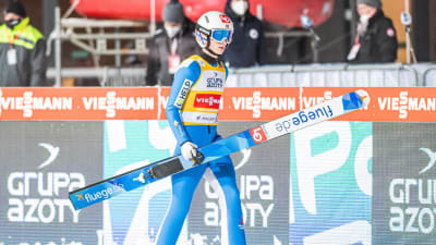 Halvor Egner Granerud går med skidorna i händerna.