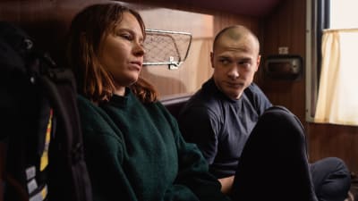 Seidi Haarla och Juri Borisov sitter bredvid varandra i en tågkupé.