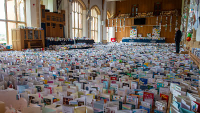 Tiotusentals födelsedagskort utlagda på golvet till aulan i en skola