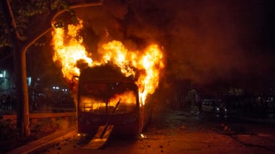 En av de många bussar som demonstranter brände upp under bråken på fredag kväll i Santiago. 