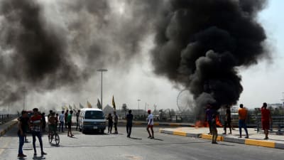 Demonstranter bränner bildäck i östra Bagdad