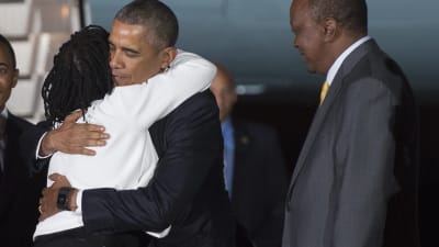 Obama möts av sin halvsyster Auma Obama och president Uhuru Kenyatta på Nairobis flygfält, Kenya.