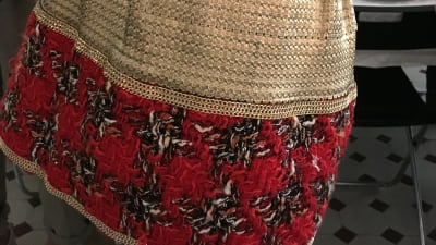 En kort kjol med gulbrokadtyg och stickade röda detaljer.