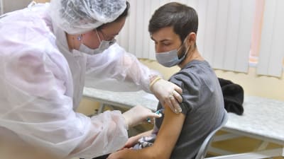 En man som får en injektion med vaccinet Sputnik V på en poliklinik i Moskva