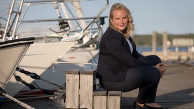 Michelle Grönlund sitter på en brygga. Båtar i bakgrunden. 