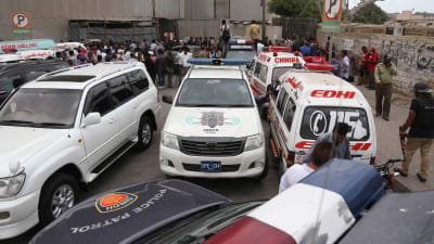 Polisbilar och ambulanser utanför börsen i Karachi.