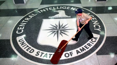 Univormupukuinen mies lakaisee lattiaa. Lattiassa on Yhdysvaltain keskustiedustelupalvelun CIA:n sinetti.
