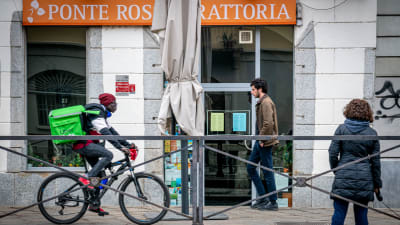 Ett cykelbud väntar på att leverera mat i Milano mitt under coornaepidemin.