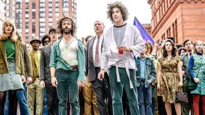THE TRIAL OF THE CHICAGO 7, foreground from left: Caitlin Fitzgerald as Daphne O'Connor, Alex Sharp as Rennie Davis, Jeremy Strong as Jerry Rubin, John Carroll Lynch as David Dellinger, Sacha Baron Cohen as Abbie Hoffman, 2020.