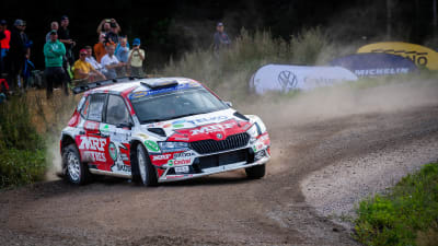 En rallybil kommer fort in i en kurva.