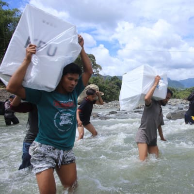 Indonesier transporterar valurnor över ett vattendrag.