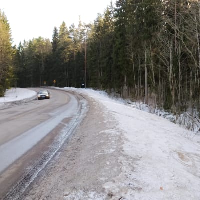 En vinterslaskig väg, i förgrunden syns en blå vägskylt med texten Borgå 6 och Sondby 13.