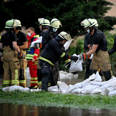 Räddningsarbetare försöker stoppa översvämningarna med att bygga rader med sandsäckar.