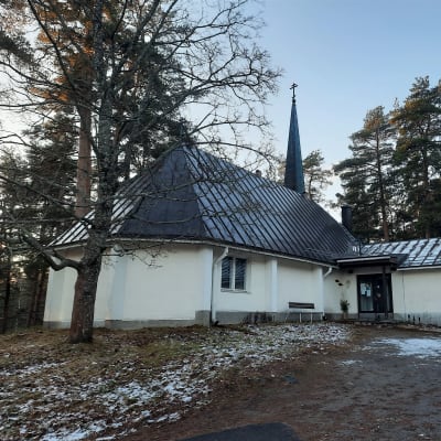 Savonlinnassa sijaitseva ortodoksikirkko ulkoa päin kuvattuna. Kuvassa näkyy valkoinen kirkkorakennus ja sen tumma katto. Taustalla myös terävä kirkontorni.