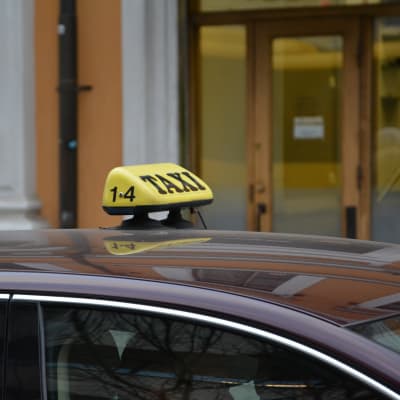 En gul taxiskylt på en bil i centrum av Åbo.