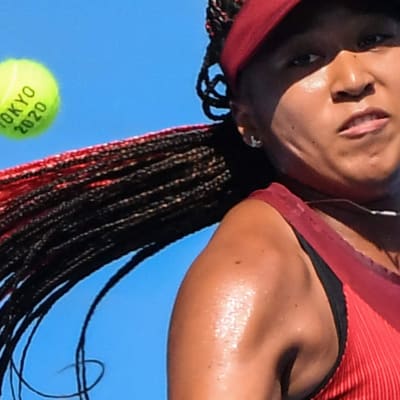 Närbild på Naomi Osaka med en tennisboll i närheten av huvudet.
