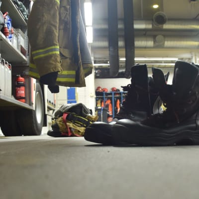 Skor på golvet i en brandstation, färdiga att ta på sig vid utryckning.