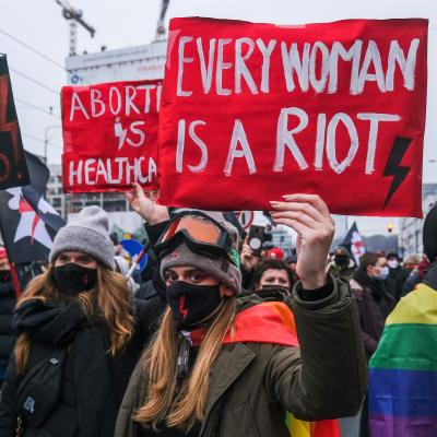 Aborttimielenosoitukseen osallistuvat naiset näyttävät kylttejä.