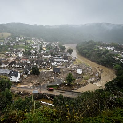 Joki ja kylä, jossa tuhoutuneita rakennuksia.