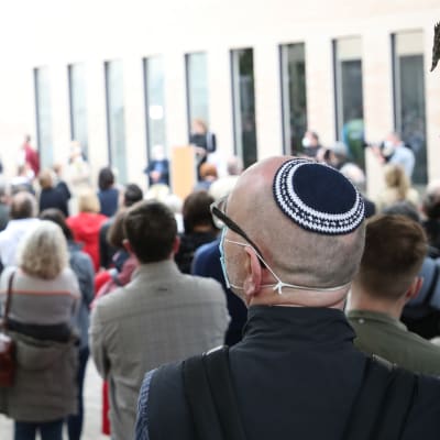 Person med Kippa i folkmassa under protest mot antisemitism. 