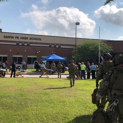 Poliser och sjukvårdspersonal och representanter för medierna utanför Santa Fe High School efter massakern där.